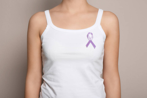 Woman wearing purple ribbon on grey background, closeup. Domestic violence awareness - Fotografie, Obrázek