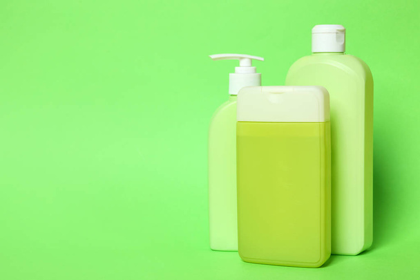 Garrafas de shampoo em fundo verde, espaço para texto. Produtos cosméticos naturais
 - Foto, Imagem