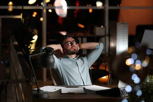Young man working in office at night - Photo, Image