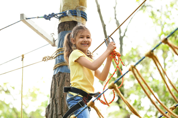 Little girl climbing in adventure park. Summer camp - Foto, Imagen