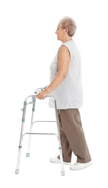 Retrato de longitud completa de una mujer anciana usando un marco para caminar aislado en blanco
 - Foto, Imagen