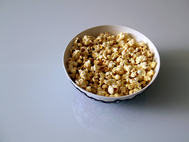 top view of a pile of popcorn caramel popcorn in a plate on a glass table - Φωτογραφία, εικόνα