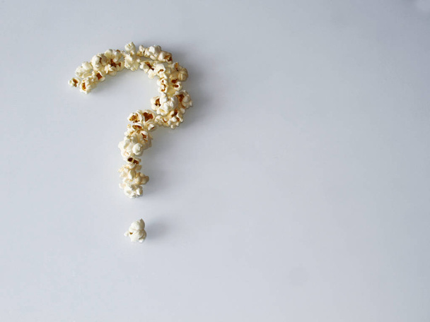 popcorn laid out in the form of a question on a white background - Фото, изображение