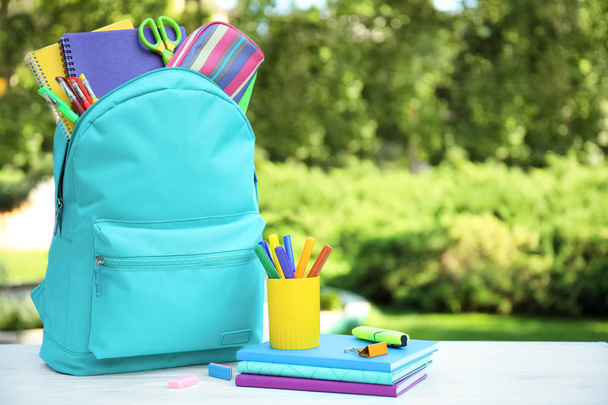 Bright backpack and school stationery on table outdoors, space for text - Foto, immagini
