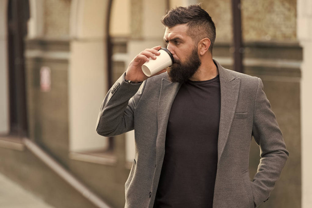 Relax and recharge. Man bearded hipster drinking coffee paper cup. One more sip of coffee. Drinking coffee on the go. Businessman lumbersexual appearance enjoy coffee break out of business center - Fotografie, Obrázek
