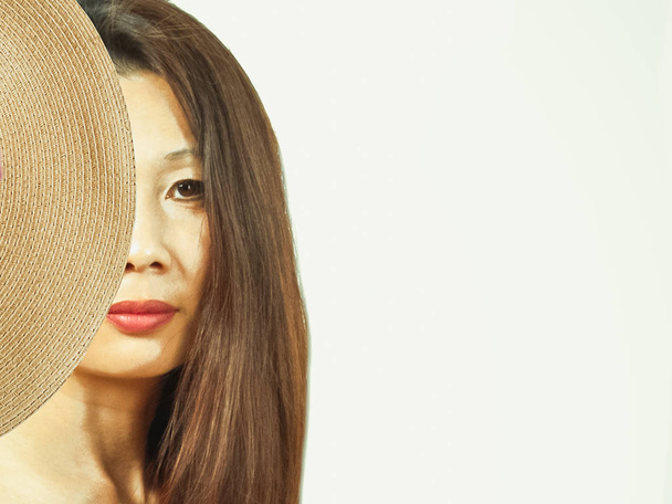 half face of an asian woman, closed straw hat-beauty or summer c - Foto, imagen