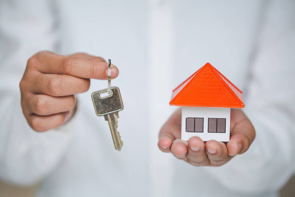 Агент по недвижимости с моделью дома и ключами, недвижимостью и про
 - Фото, изображение