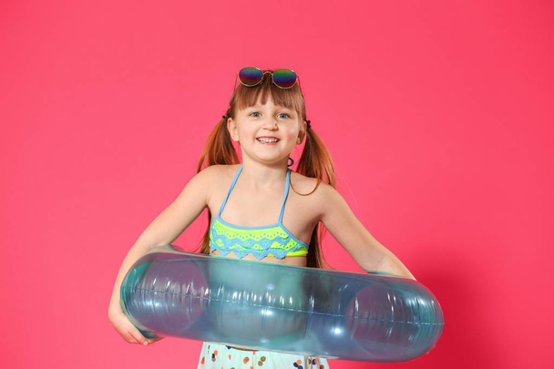 Cute little girl with inflatable ring on color background - Photo, Image