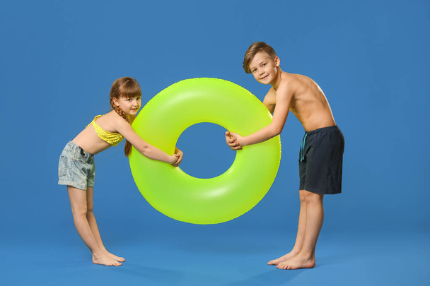 Cute little children with inflatable ring on color background - Photo, Image