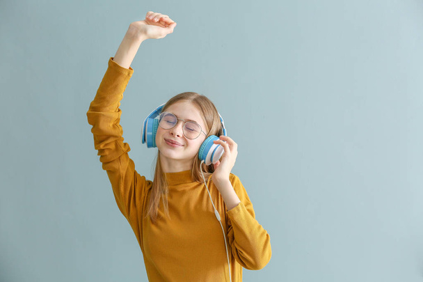 niedliche Teenager-Mädchen hören Musik auf farbigem Hintergrund - Foto, Bild