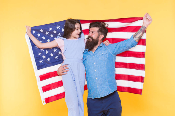 How do americans celebrate independence day. Father bearded hipster and cute little daughter with USA flag. Patriotic family cheerful and friendly. Independence day holiday. Independence is happiness - 写真・画像