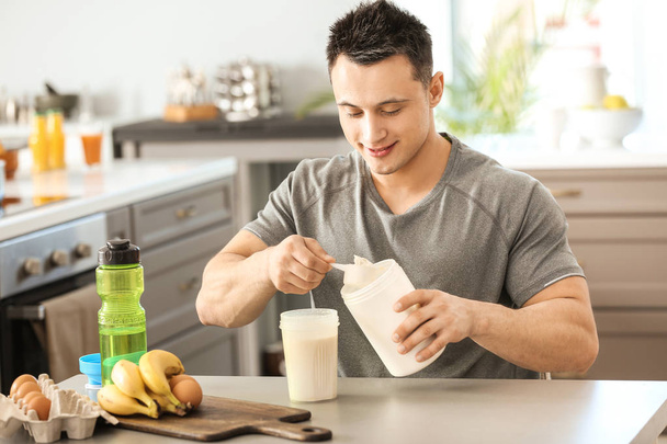 Sporty man making protein shake at home - Foto, imagen