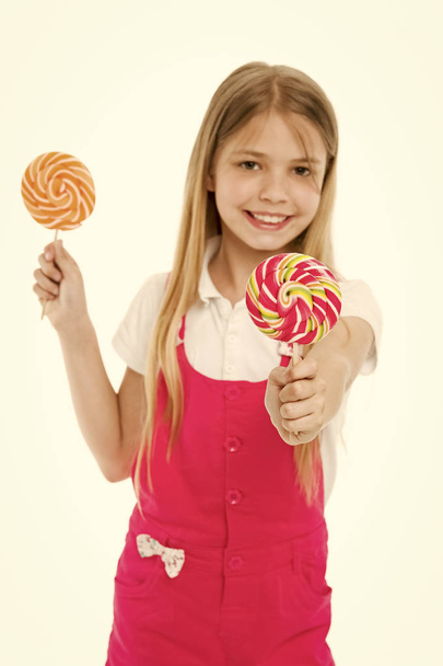 Little child smile with lollipops isolated on white. Happy girl hold candies on sticks. Sharing candy with you. Candyshop concept. Childhood and happiness. Kid smiling with swirl caramels. Sweet mood - Fotoğraf, Görsel