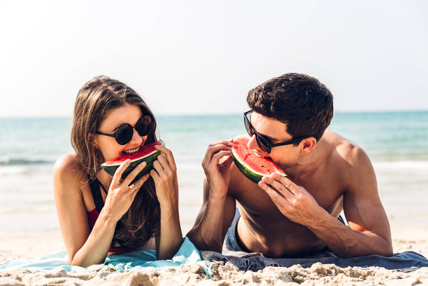 Amantes románticos pareja joven relajándose sosteniendo y comiendo una rebanada
 - Foto, imagen