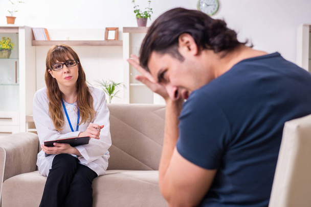 Νεαρός άνδρας ασθενής συζητά με γυναίκα ψυχολόγο  - Φωτογραφία, εικόνα
