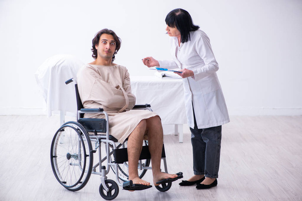 Old female psychiatrist visiting young male patient  - Photo, Image