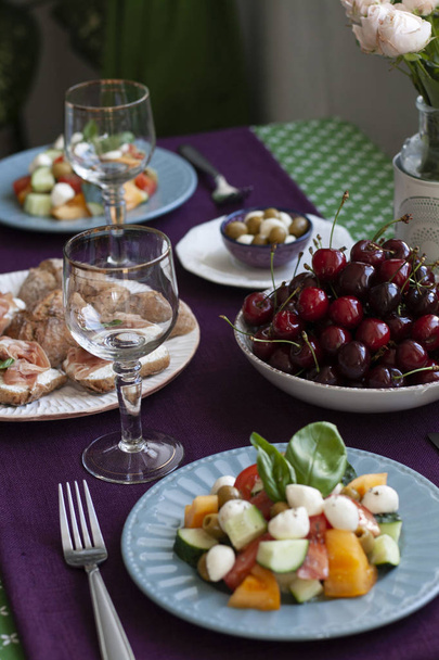 Обед для гурманов на двоих: салат, свежие вишни и различные приложения
 - Фото, изображение