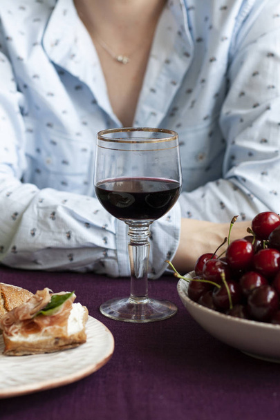 Gourmet-Pause: ein Glas Wein, Kirschen und Baguettescheiben - Foto, Bild