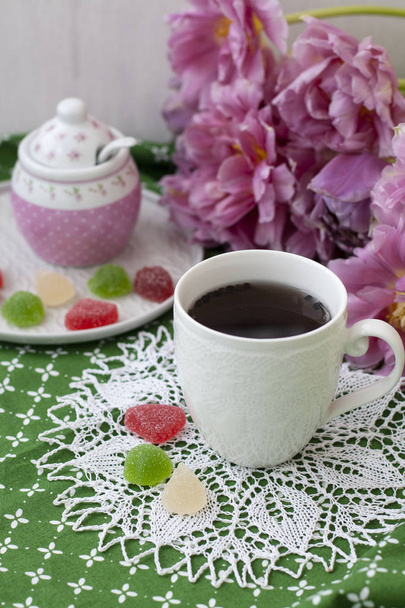 A tasty treat: a cup of tea and a plate of fruit jellies. - Photo, Image