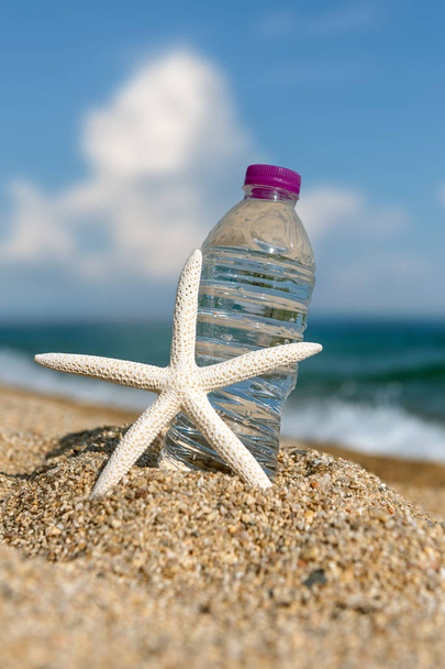 Пляшка свіжої холодної води на пляжному піску
 - Фото, зображення