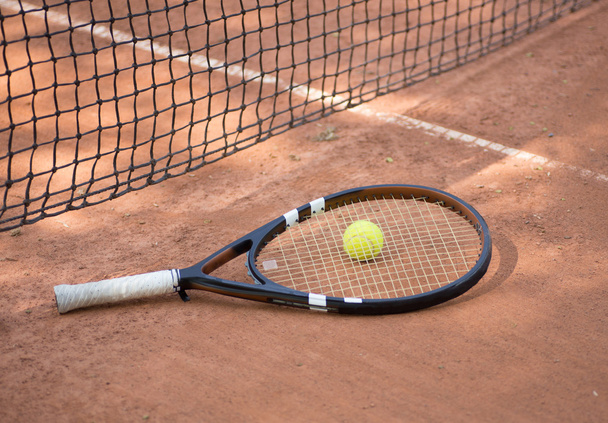 Raquette de tennis et balles sur le terrain d'argile
 - Photo, image