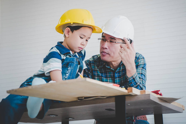 Engineer Father is teaching his son to read the construction pla - Foto, afbeelding