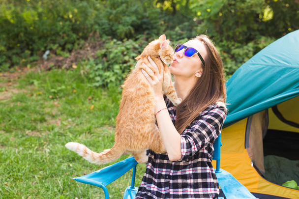 人、夏の観光と自然概念 - テントの近くの猫を持つ若い女性 - 写真・画像