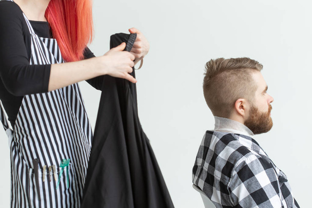 Hairdresser, stylist and barber shop concept - young woman hairstylist is going to cut a man - Photo, Image