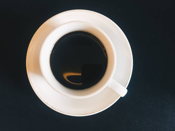 Czarna kawa lub espresso w szklance z widokiem na górę na czarnym tle. powyżej filiżanki kawy - Zdjęcie, obraz