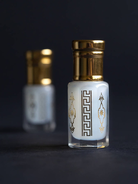 Concentrated perfume in a mini bottle on the black table - Photo, Image
