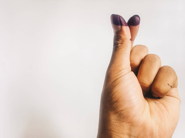 dedo sinal de amor coreano para peça e símbolo vivo da mão de um homem com manchas de tinta azul isolados em um fundo branco. manchas de tinta azul dos dedos da eleição presidencial da Indonésia
 - Foto, Imagem