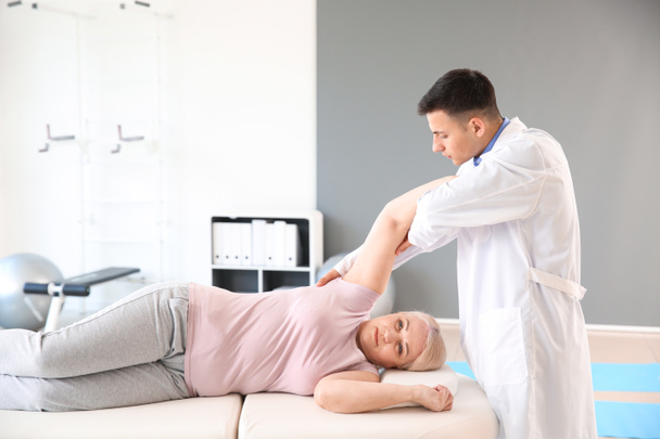 Physiotherapist working with mature patient in rehabilitation center - Fotografie, Obrázek