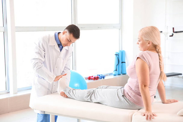 Physiotherapist working with mature patient in rehabilitation center - Zdjęcie, obraz