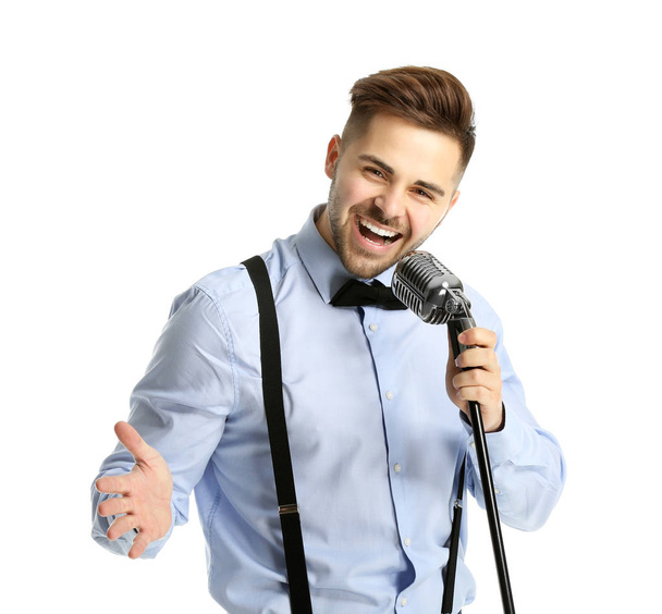 Όμορφος άντρας τραγουδιστής με μικρόφωνο σε λευκό φόντο - Φωτογραφία, εικόνα