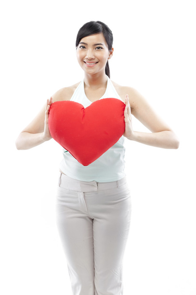 Portrait of attractive asian smiling woman and hand holding red heart isolated on white studio shot - Foto, Bild