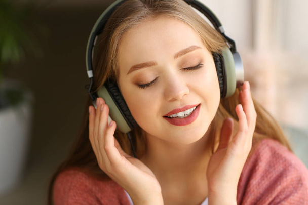 Beautiful young woman listening to music at home - Foto, Imagem