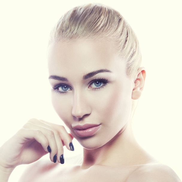 Porträt einer jungen Frau mit natürlichem Make-up mit zartem Blick auf weißem Hintergrund - Foto, Bild