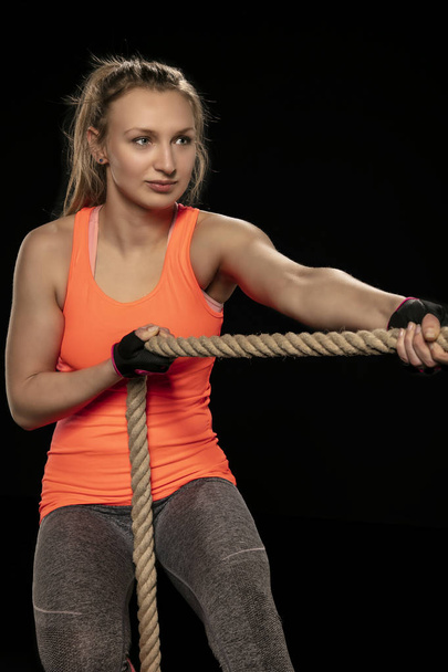 athletic girl exercising with a thick rope - 写真・画像