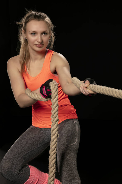 athletic girl exercising with a thick rope - Foto, afbeelding