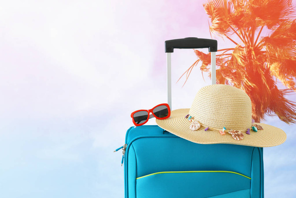 vacaciones. concepto de viaje. maleta azul frente al fondo tropical
 - Foto, Imagen