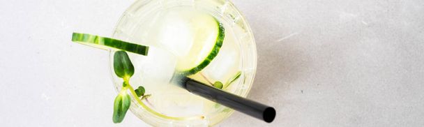 Fresh summer cocktail with cucumber garnished with cucumber slices, sprouts and micro greens - 写真・画像