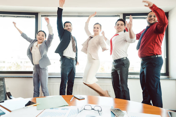 Diversità team di uomini d'affari saltando in alto in ufficio
  - Foto, immagini