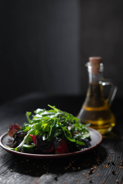 Řecký salát s okurkou, bazalkou, rajčaty, arugula, krásně položená na hliněné desce - Fotografie, Obrázek