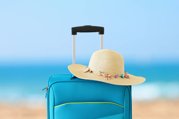 vacaciones. concepto de viaje. maleta azul frente al fondo tropical
 - Foto, imagen