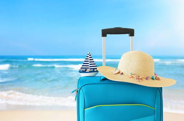 holidays. travel concept. blue suitcase infront of tropical background - Fotó, kép