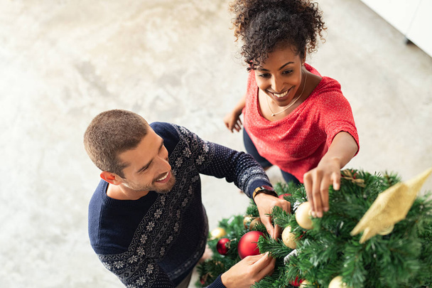 Young couple decorating xmas tree - Foto, immagini