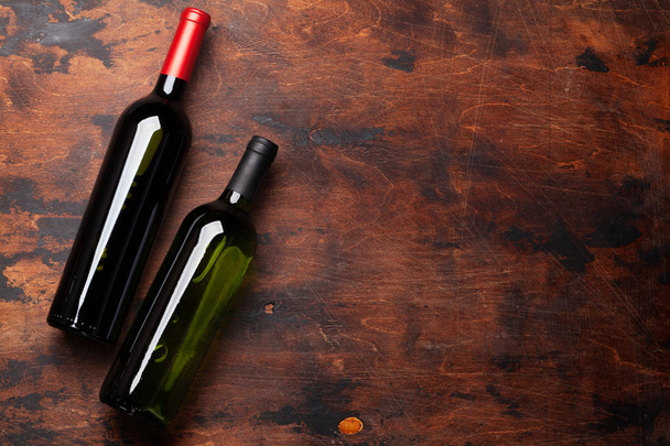 Різні пляшки вина на дерев'яному столі
 - Фото, зображення