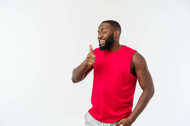 jovem afro-americano homem sobre isolado fundo vestindo esporte desgaste sorrindo com feliz rosto olhando com o polegar para cima
. - Foto, Imagem
