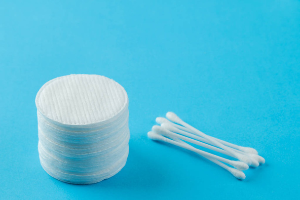 Cosmetic cotton pads. a stack of cotton pads and cotton swabs on a gentle light blue background. spa. close-up. - Foto, Imagem