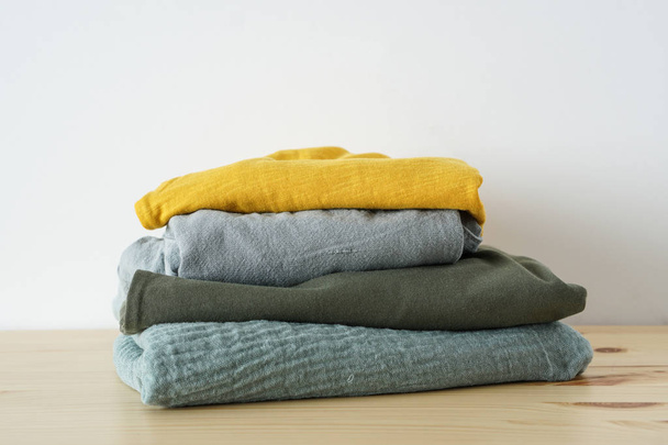 Stack of summer clothes on wooden table - Photo, Image